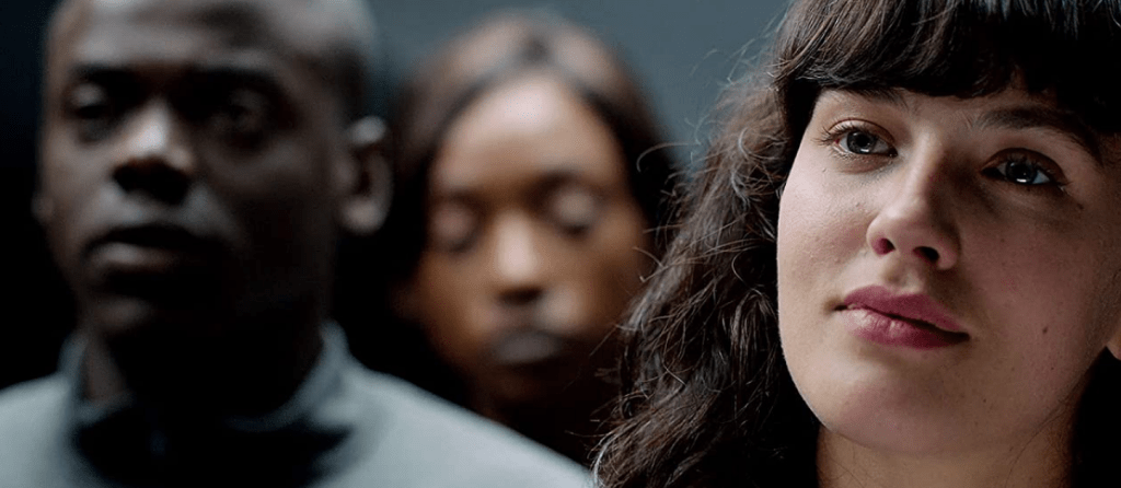 An elevator. A close up of Abi's face. Bing and another worker are blurrily visible behind her